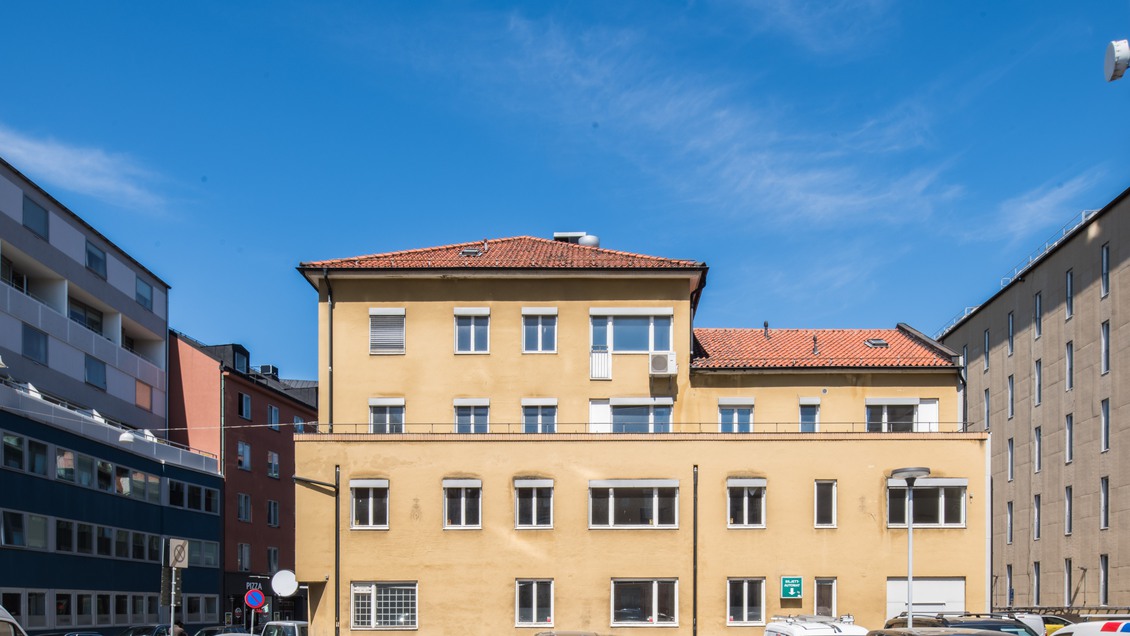 Fasaden på ett gult hus beläget mitt i Malmö centrum 